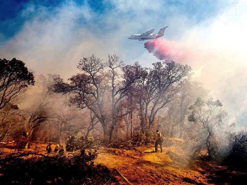 An air tanker drops retardant on the Olinda Fire in Anderson, Calif., Sunday, Oct. 25, 2020. The blaze was one of four fires burning near Redding that firefighters scrambled to stop as high winds buffeted Northern California. Image Credit: AP